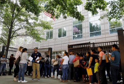 An Immigration and Customs Enforcement official assists people waiting to enter immigration court in Atlanta, June 12, 2019. U.S. authorities are fast-tracking families' cases to discourage many from making the journey to seek refuge in the United States.