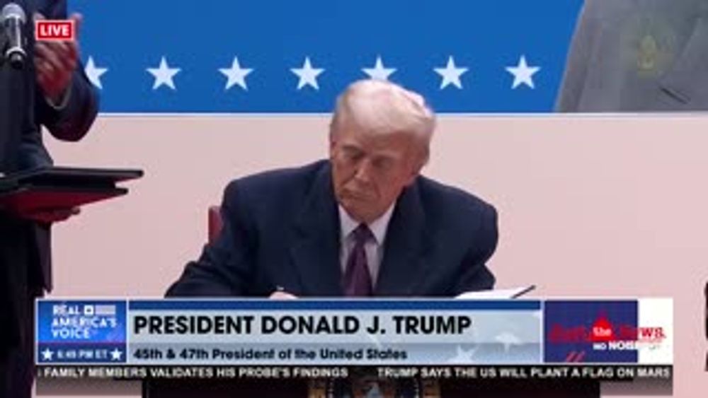 PRESIDENT TRUMP SIGNING EXECUTIVE ORDERS ON STAGE AT CAPITAL ONE ARENA.