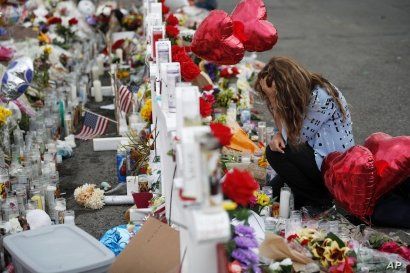 Gloria Garces kneels in front of crosses at a makeshift memorial near the scene of a mass shooting at a shopping complex Tuesday, Aug. 6, 2019, in El Paso, Texas. The border city jolted by a weekend massacre at a Walmart absorbed more grief Monday…