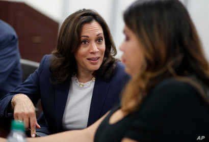 FILE - In this June 14, 2019, file photo, Democratic presidential candidate Sen. Kamala Harris, D-Calif., left, speaks with…
