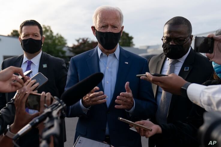 Democratic presidential candidate former Vice President Joe Biden, flanked by members of his Secret Service detail, speaks to…
