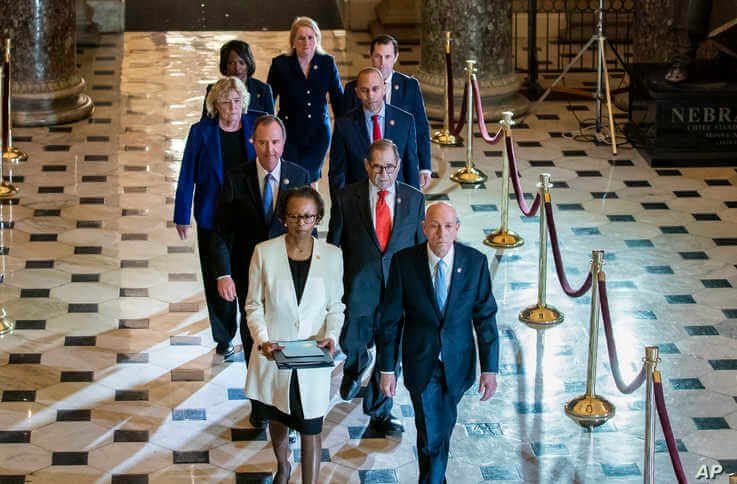 Clerk of the House Cheryl Johnson, left, and House Sergeant at Arms Paul Irving pass through Statuary Hall at the Capitol