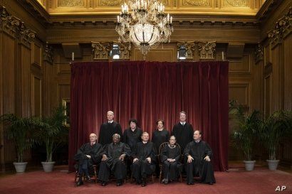FILE - In this Nov. 30, 2018, file photo, the justices of the U.S. Supreme Court gather for a formal group portrait to include a new Associate Justice, top row, far right, at the Supreme Court Building in Washington. Seated from left: Associate…