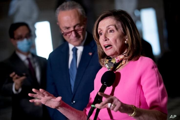 House Speaker Nancy Pelosi of Calif., center, accompanied by Senate Minority Leader Sen. Chuck Schumer of N.Y., left, speak to…