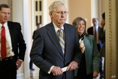 In this Oct. 29, 2019, photo, Senate Majority Leader Mitch McConnell of Ky., center, walks to the podium with Sen. John…