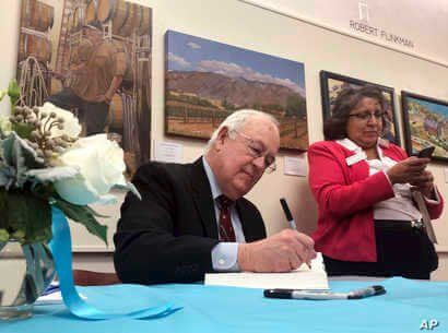 Former independent counsel Kenneth Starr signs a copy of his recent book 