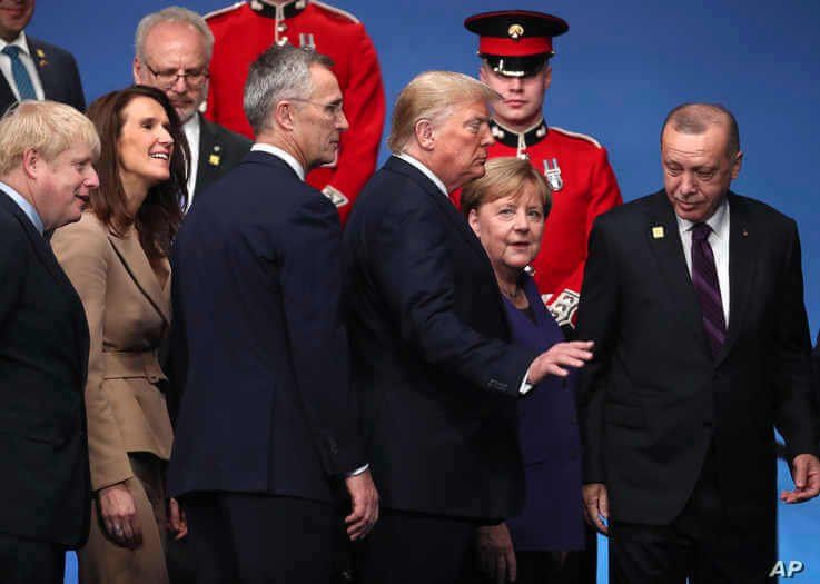 U.S. President Donald Trump, center left, speaks with German Chancellor Angela Merkel, center right, during a ceremony event.