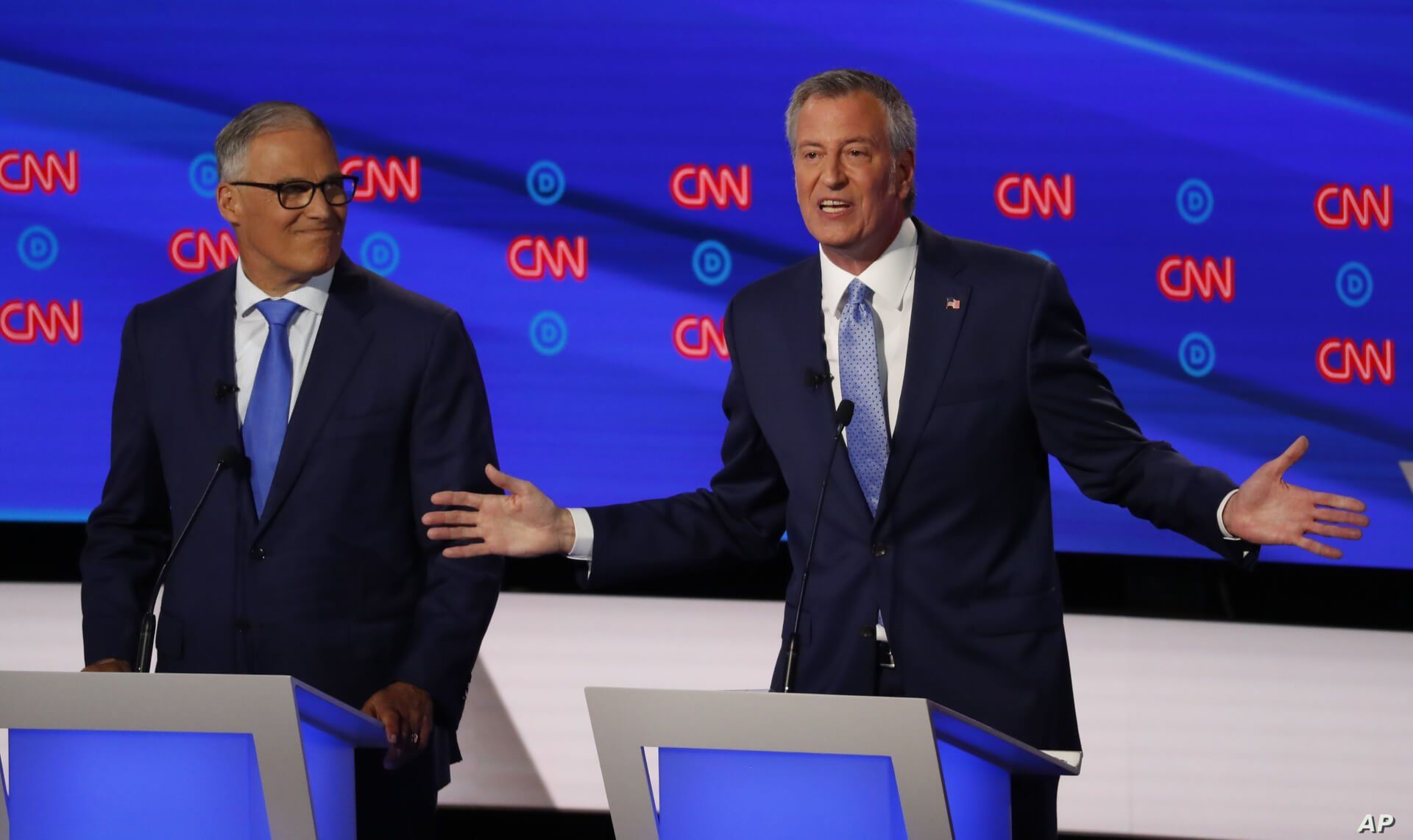 Washington Gov. Jay Inslee listens as New York City Mayor Bill de Blasio speaks during the second of two Democratic presidential primary debates hosted by CNN, July 31, 2019, in the Fox Theatre in Detroit.