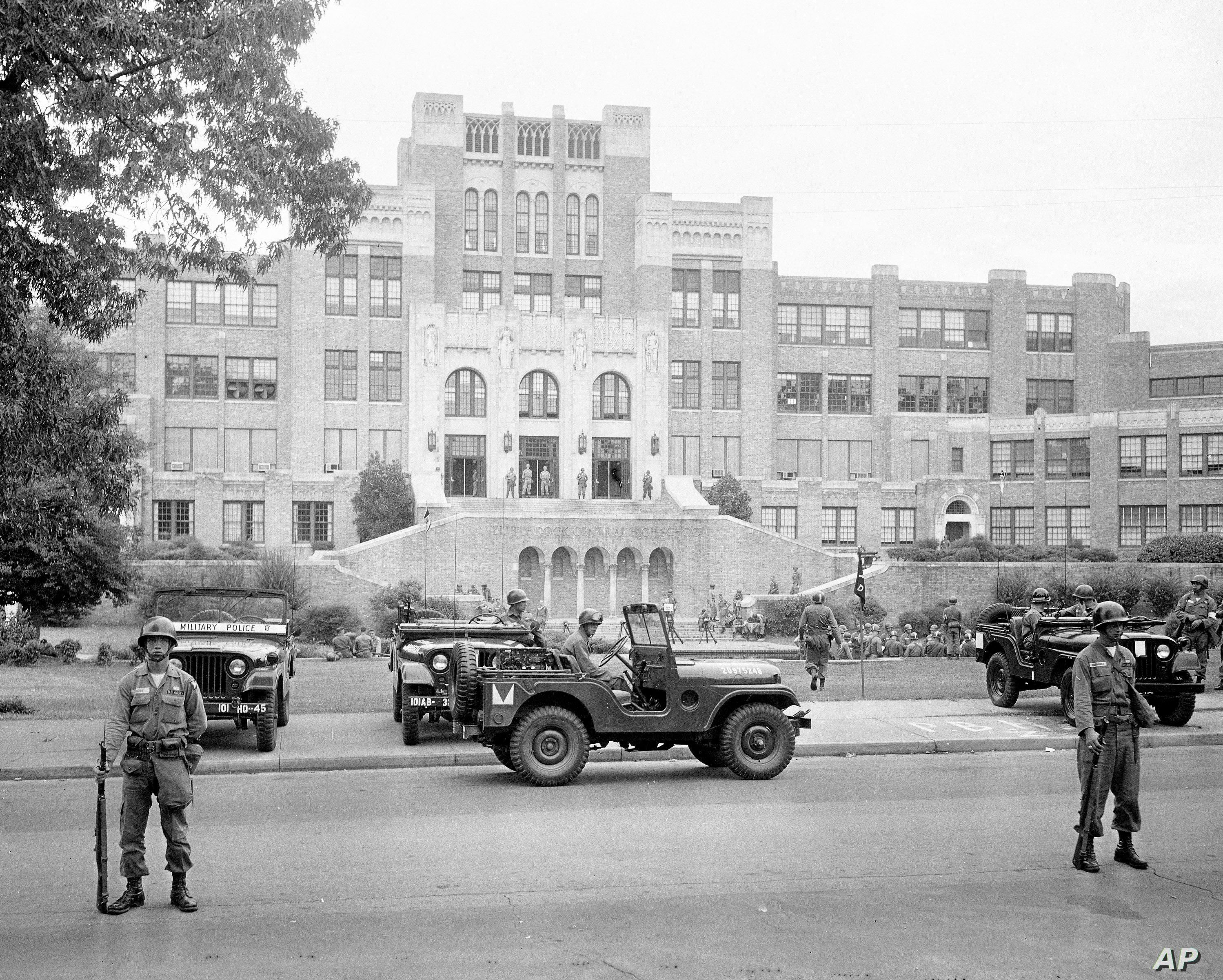 In this Sept. 26, 1957, file photo, members of the 101st Airborne Division take up positions outside Central High School in Little Rock, Ark., after President Dwight D. Eisenhower ordered them into the city to enforce integration at the school. 