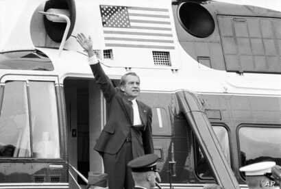FILE - In this Aug. 9, 1974 file photo, President Richard Nixon waves goodbye from the steps of his helicopter outside the…