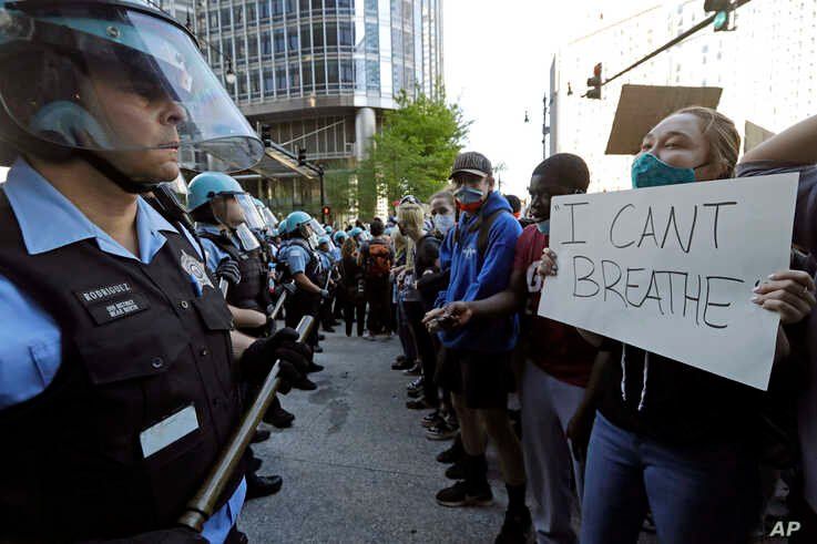 People confront police officers during a protest over the death of George Floyd in Chicago, Saturday, May 30, 2020. Protests…