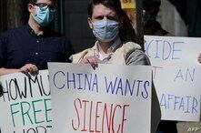 Protestors hold signs as they gather during a rally for Uyghur Freedom in New York on March 22, 2021. - The rally is for Uyghur…