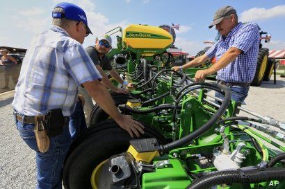 Visitors to the Husker Harvest Days farm show in Grand Island, Neb., look over John Deere equipment, Tuesday, Sept. 10, 2019. (AP Photo/Nati Harnik)