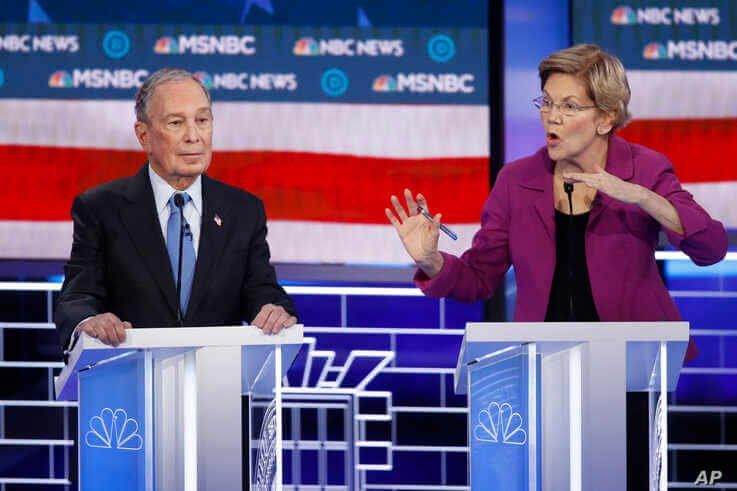 Democratic presidential candidates, former New York City Mayor Mike Bloomberg, left, listens as Sen. Elizabeth Warren, D-Mass.,…