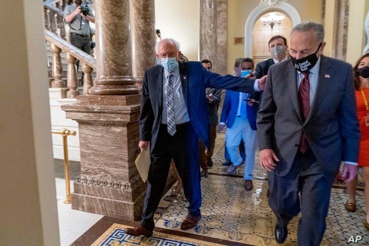 Sen. Bernie Sanders, I-Vt., left, and Senate Majority Leader Chuck Schumer of N.Y., right, walk out of a budget resolution…
