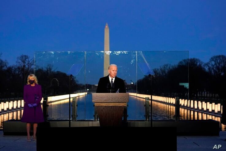 President-elect Joe Biden speaks during a COVID-19 memorial, with lights placed around the Lincoln Memorial Reflecting Pool,…