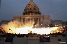 An explosion caused by a police munition is seen while supporters of U.S. President Donald Trump gather in front of the Capitol Building in Washington, D.C., Jan. 6, 2021.