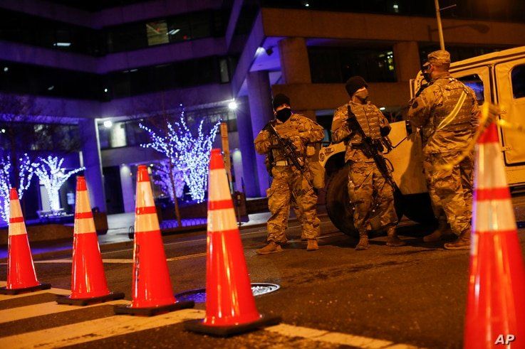 National Guard personnel and police secure a street near the Capitol, Sunday, Jan. 17, 2021, in Washington, as part of…