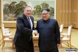 FILE - North Korean leader Kim Jong Un shakes hands with U.S. Secretary of State Mike Pompeo in this May 9, 2018, photo released by North Korea's Korean Central News Agency (KCNA) in Pyongyang.