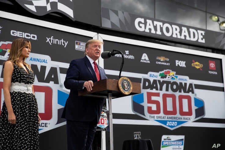 President Donald Trump, accompanied by first lady Melania Trump, speaks before the start of the NASCAR Daytona 500 auto race 