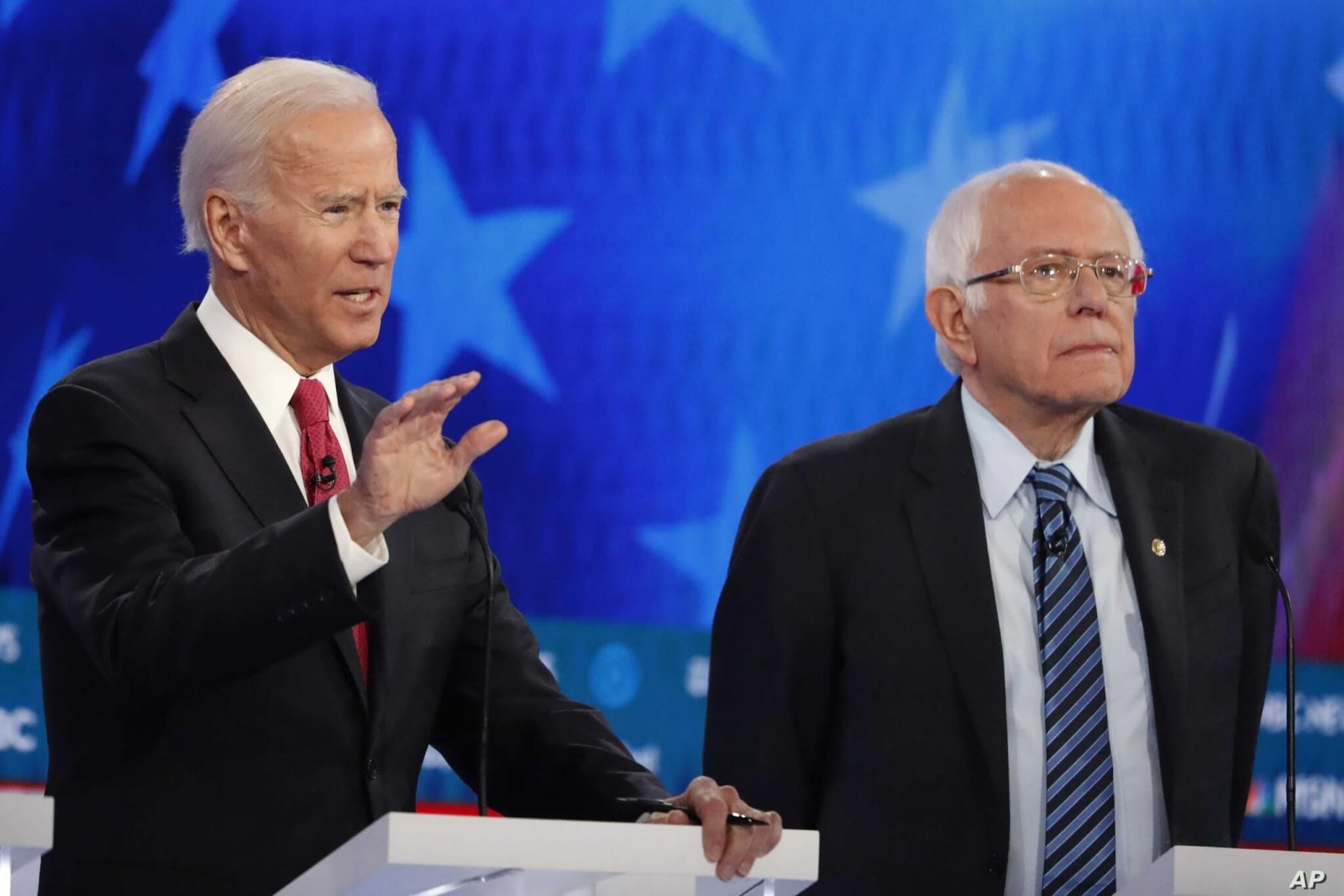 Democratic presidential candidate former Vice President Joe Biden, left, speaks as rival Sen. Bernie Sanders listens