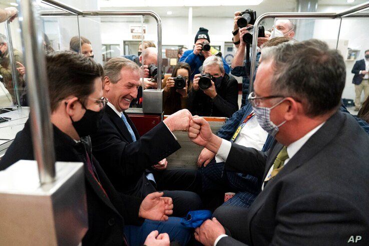 Michael van der Veen, second from left an attorney for former President Donald Trump, fist bumps a colleague as the depart on…