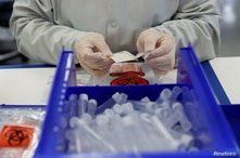 A technician assembles coronavirus test kits at Evolve manufacturing facility, where they will be manufacturing ventilators, in…
