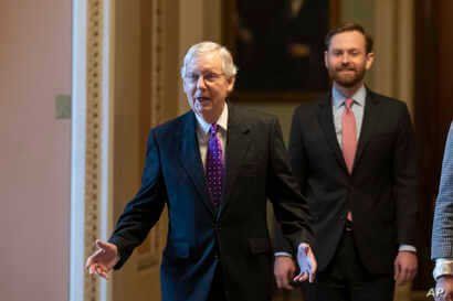 Senate Majority Leader Mitch McConnell of Ky., left, walks from the Senate Floor on Capitol Hill, Feb. 4, 2020 in Washington.