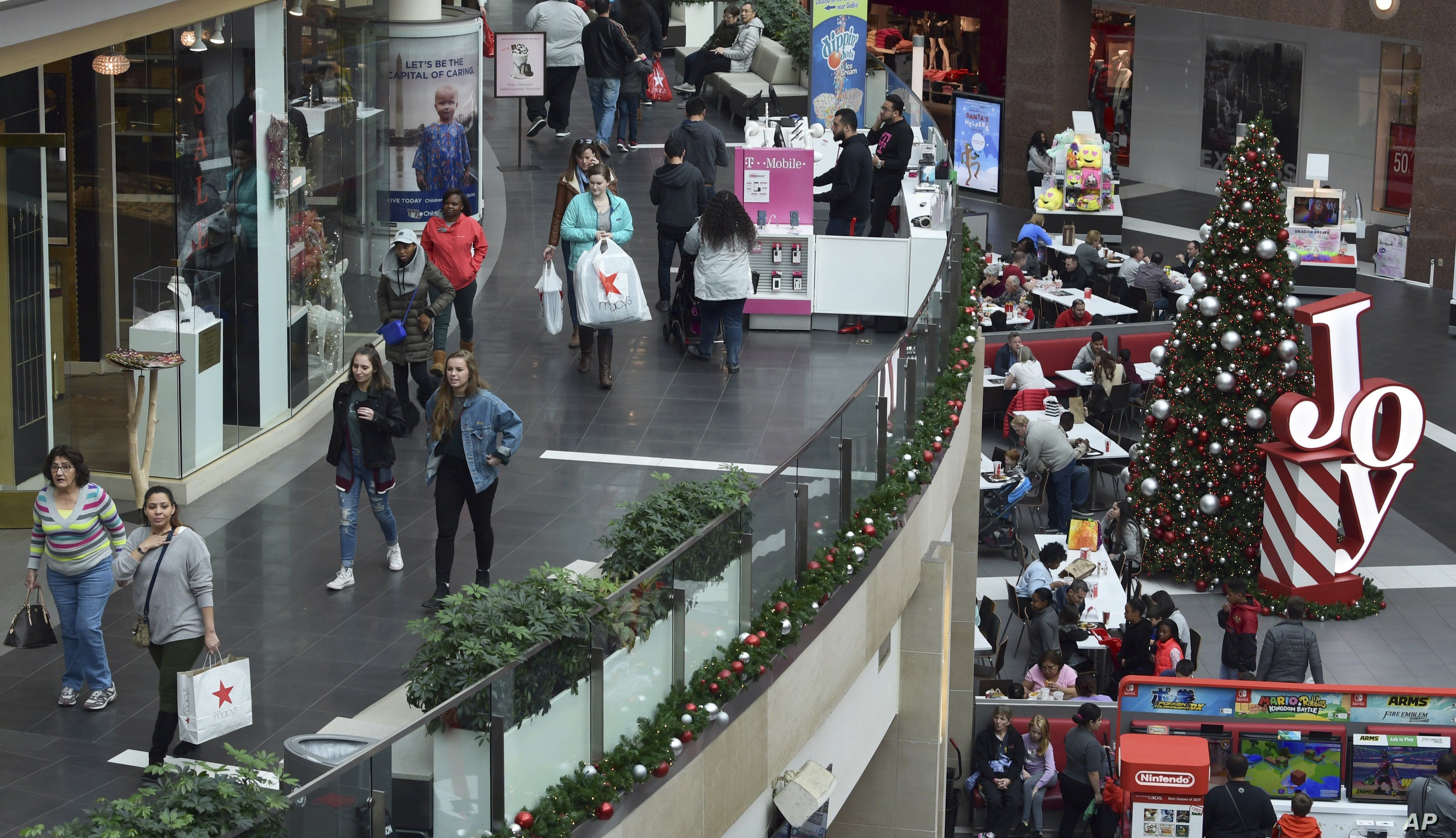FILE- In this Dec. 22, 2017, file photo people shop at the Pentagon City Mall in Arlington, Va. 