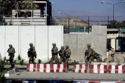U.S. military forces stand guard at the site of a suicide attack near a U.S. military camp in Kabul, Afghanistan, Tuesday, Sept. 16, 2014. A Taliban suicide car bomber attacked a foreign motorcade just a couple hundred yards (meters) from the U.S. Em