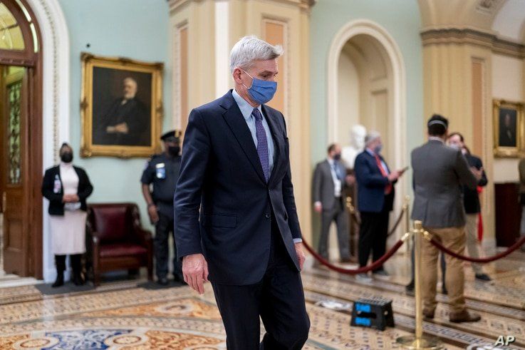 FILE - Republican Senator Bill Cassidy leaves the chamber as the Senate voted to consider hearing from witnesses in the impeachment trial of former President Donald Trump, at the Capitol in Washington, Feb. 13, 2021.