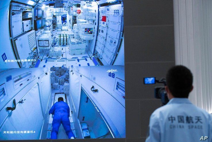In this photo released by Xinhua News Agency, a worker monitors screens showing the interior of the Tianhe space station module…