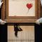 Shredded painting by British artist Banksy re-sold for $25.4 million at auction in London