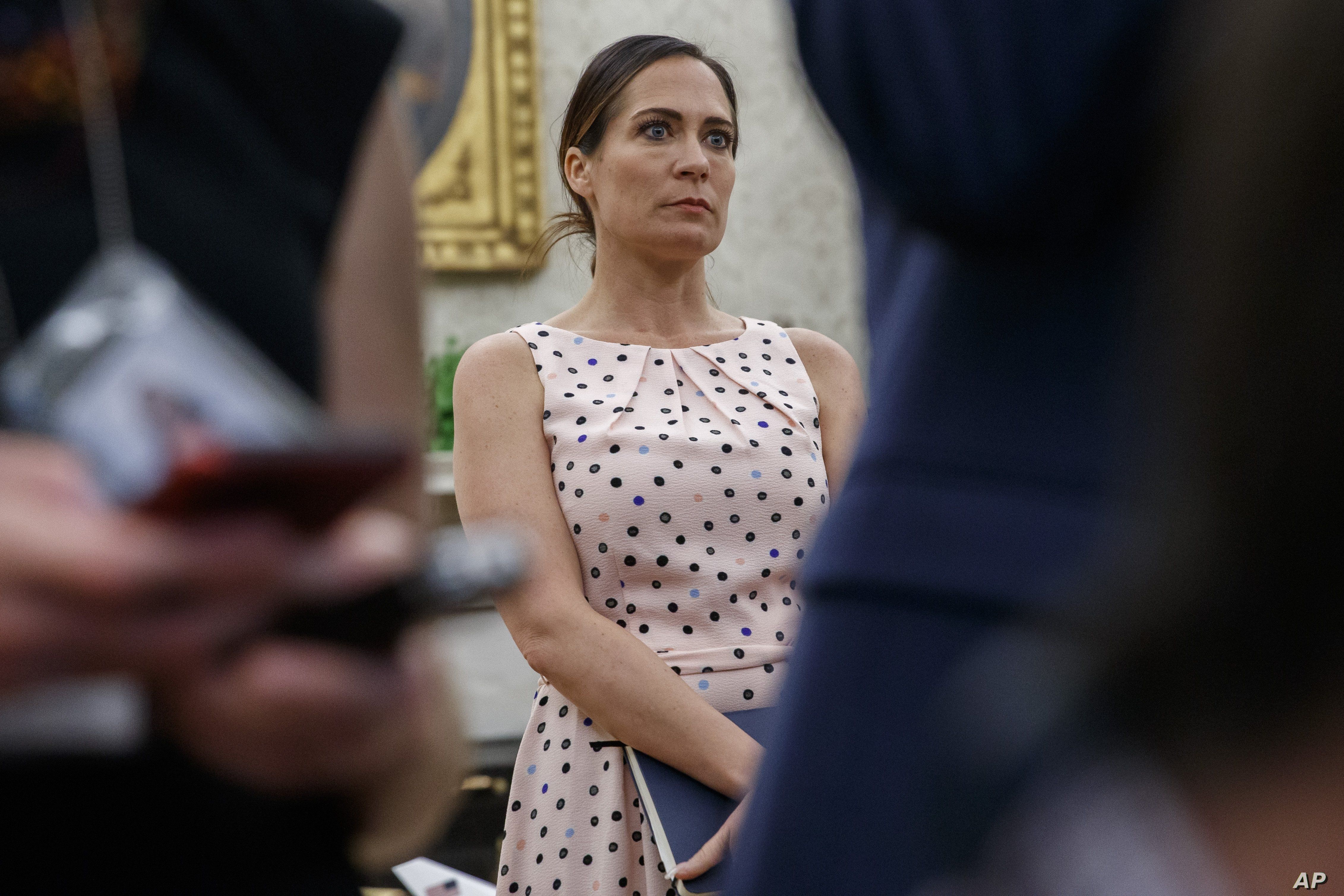 White House press secretary Stephanie Grisham, listens as President Donald Trump speaks with reporters on the South Lawn of the White House before departing, Wednesday, July 17, 2019, in Washington. (AP Photo/Alex Brandon)
