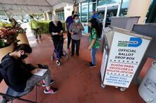 Voters prepare to turn in their mail-in ballots, Oct. 6, 2020, at the Miami-Dade County Elections Department in Doral, Florida.