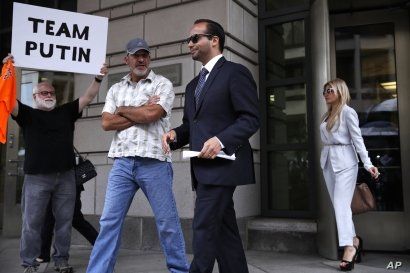 Former Donald Trump presidential campaign adviser George Papadopoulos, center, who triggered the Russia investigation and who pleaded guilty to one count of making false statements to the FBI, leaves federal court with wife Simona Mangiante, right, a