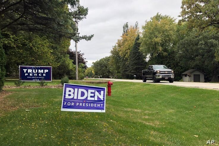 FILE - Signs for Democratic presidential candidate former Vice President Joe Biden and President Donald Trump mark neighboring properties in a middle-class neighborhood of Oshkosh, Wisconsin, Sept. 29, 2020. 