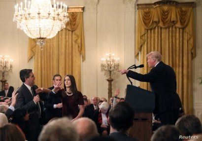 A White House staff member reaches for the microphone held by CNN's Jim Acosta as he questions U.S. President Donald Trump during a news conference following Tuesday's midterm U.S. congressional elections at the White House in Washington, U.S., Novem