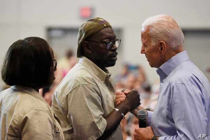 FILE - In this July 7, 2019, file photo, Democratic presidential candidate former Vice President Joe Biden, right, hold hands…