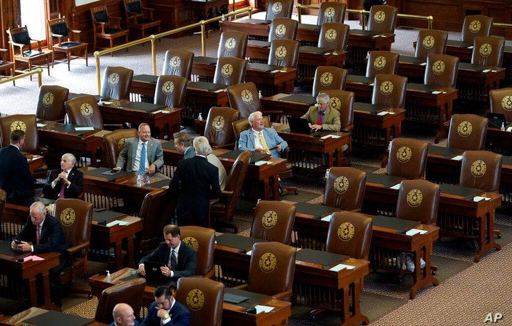 Empty seats are seen in the House Chamber at the Texas Capitol, Tuesday, July 13, 2021, in Austin, Texas. Texas Democrats left…