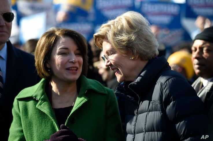 Sens. Amy Klobuchar and Elizabeth Warren speak on Jan. 20, 2020, as they line up for a Martin Luther King Jr. Day march in Columbia, S.C. 