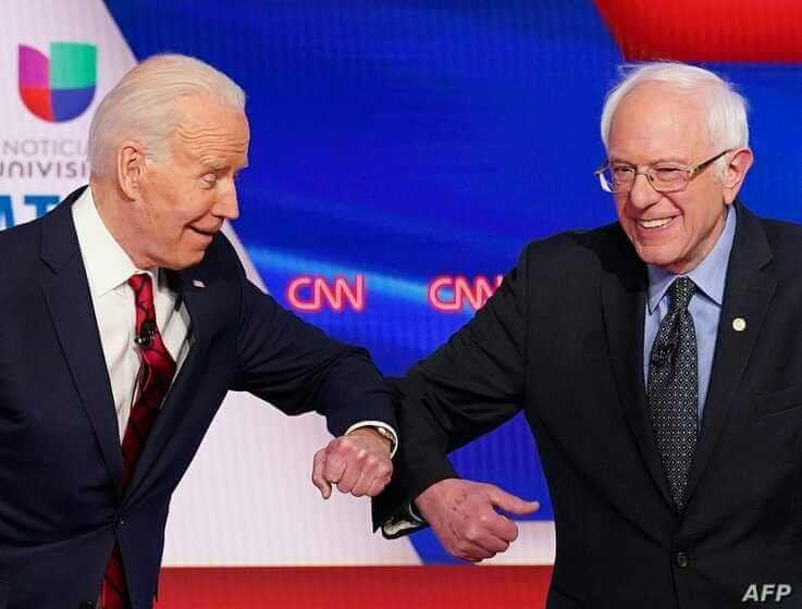 Democratic presidential hopefuls former US vice president Joe Biden (L) and Senator Bernie Sanders greet each other with a safe…