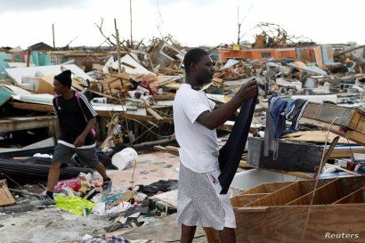 A man hangs his clothes after washing them at the Mudd neighborhood, devastated after Hurricane Dorian hit the Abaco Islands in Marsh Harbor, Bahamas, Sept. 6, 2019. 