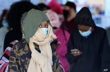 Voters brave a chilly and windy morning to cast their ballots early Friday, Oct. 30, 2020, in Covington, Ga. (AP Photo/John…