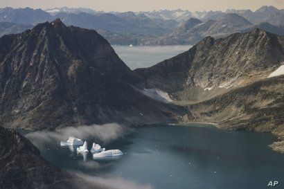 FILE - In this Aug. 14, 2019, file photo, icebergs are photographed from the window of an airplane carrying NASA scientists as they fly on a mission to track melting ice in eastern Greenland. As warmer temperatures cause the ice to retreat the…