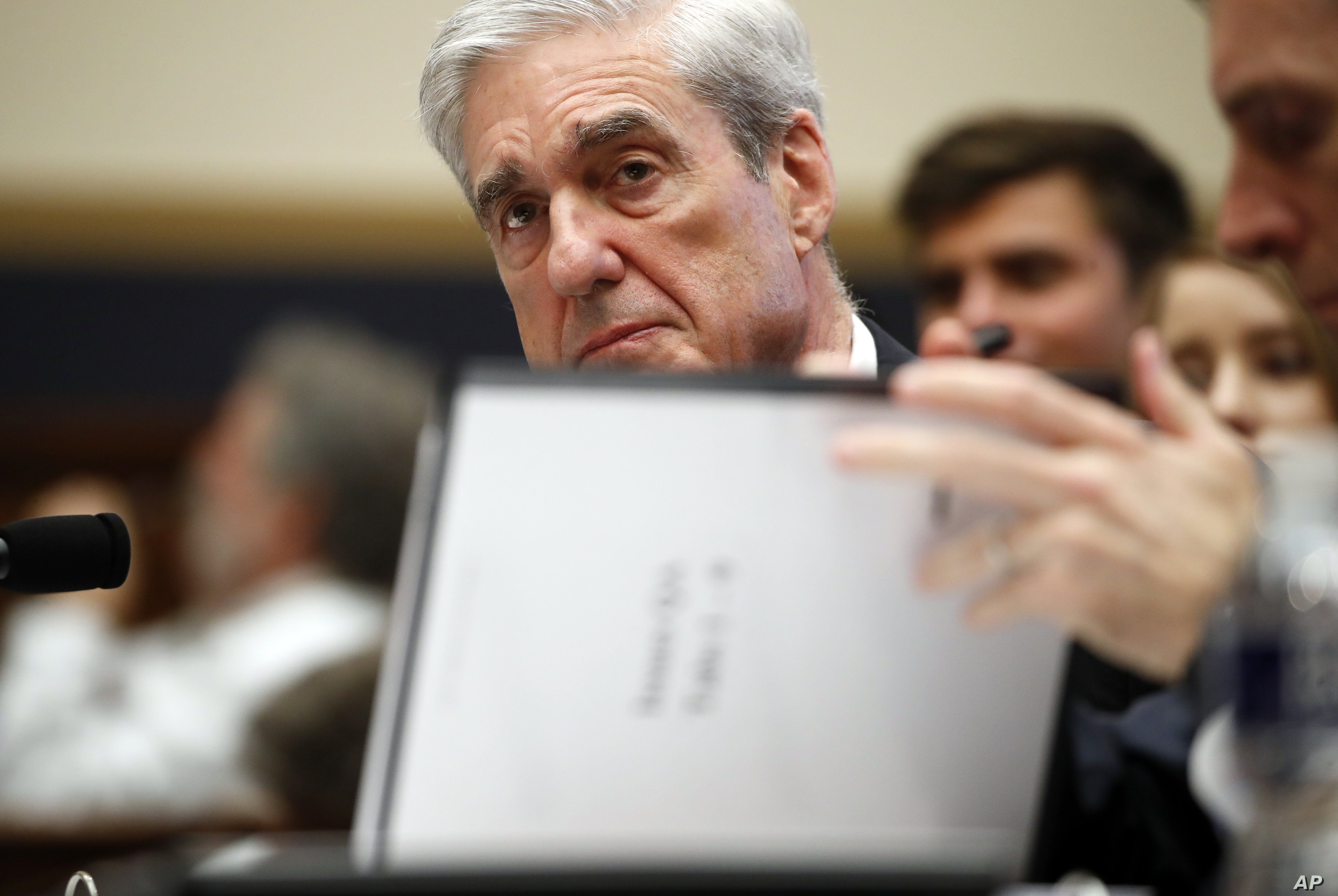 Former special counsel Robert Mueller checks pages in the report as he testifies before the House Judiciary Committee on his report on Russian election interference, Capitol Hill, July 24, 2019 in Washington.