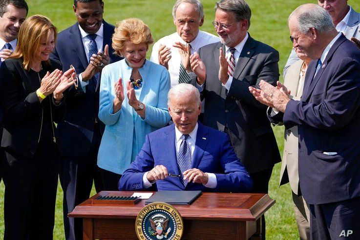 President Joe Biden signs an executive order on increasing production of electric vehicles after speaking on the South Lawn of…