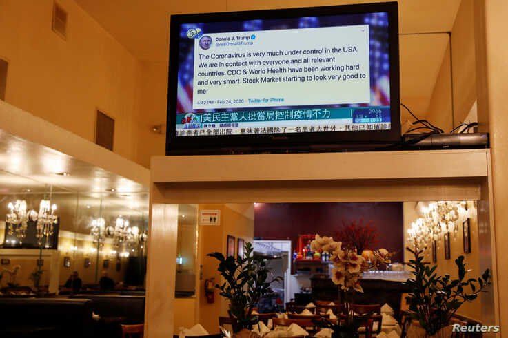 FILE - A tweet by U.S. President Donald Trump about the coronavirus is seen on a Chinese television broadcast inside a restaurant in the Chinatown section of San Francisco, California, Feb. 24, 2020. Trump tweeted before markets fell due to virus fears. 