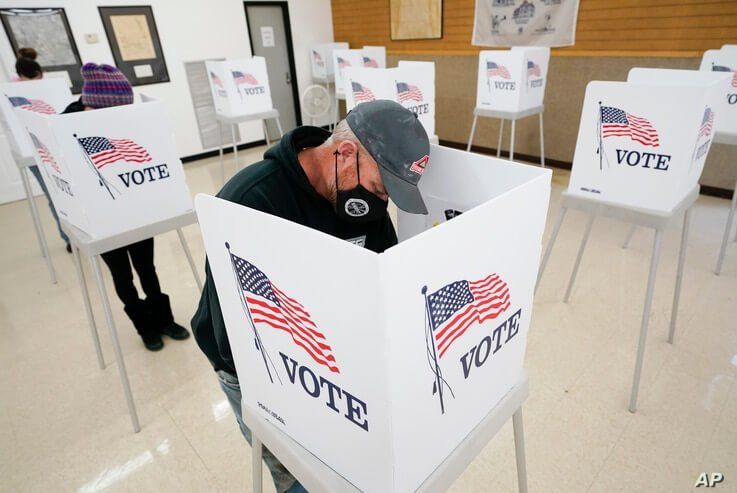 Chris Helps, of Earlham, Iowa, fills out his ballot during early voting, Tuesday, Oct. 20, 2020, in Adel, Iowa. (AP Photo…