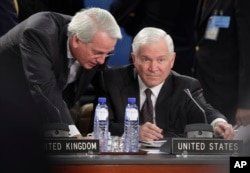 Defense Secretary Robert Gates, right, and U.S. NATO ambassador Ivo H. Daalder, talk as they prepare for a roundtable meeting of NATO defense ministers at NATO headquarters in Brussels, Oct. 14, 2010.